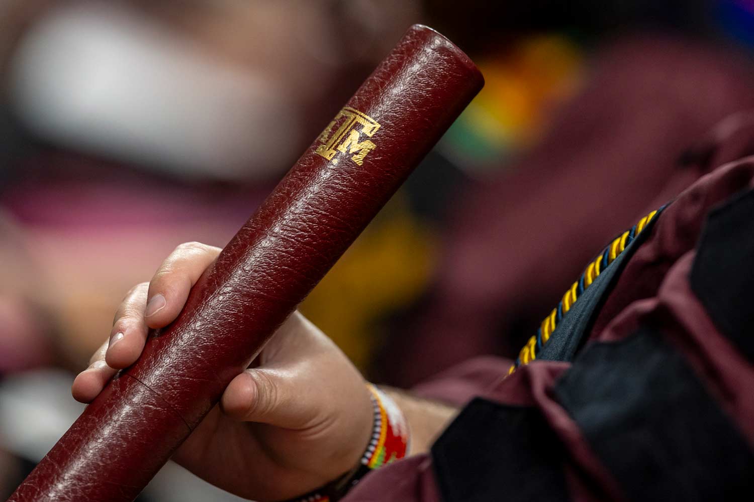 Texas A&amp;M Student hold maroon diploma tube at graduation.