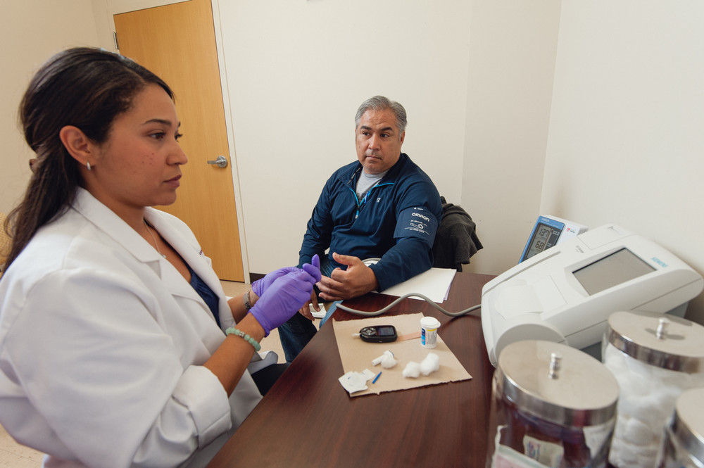 A young medical professional takes a person's blood pressure